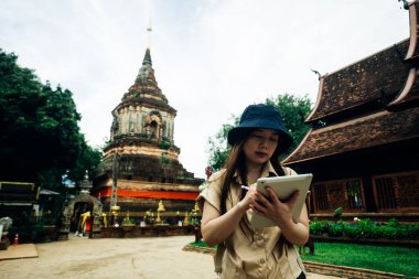 Tayland 'ın Chiang Mai bölgesindeki Ok Moli tapınağında tabletli Asyalı gezgin kadın.