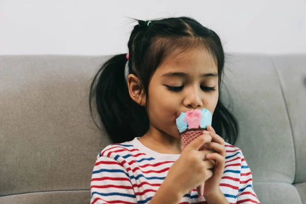 Little Asian Girl Eating Ice Cream While Sitting Sofa Home — Stock Photo, Image