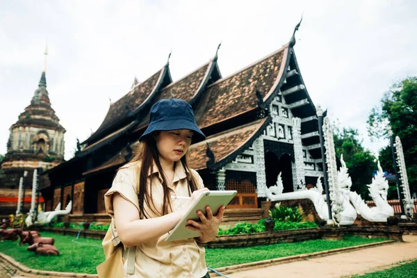 Tayland 'ın Chiang Mai bölgesindeki Ok Moli tapınağında tabletli Asyalı gezgin kadın.