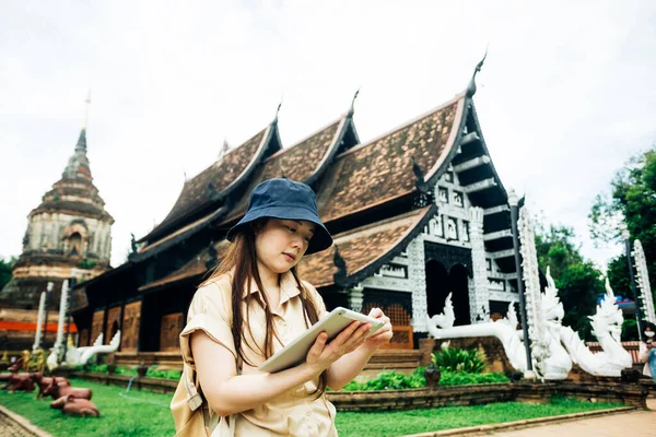 Tayland 'ın Chiang Mai bölgesindeki Ok Moli tapınağında tabletli Asyalı gezgin kadın.