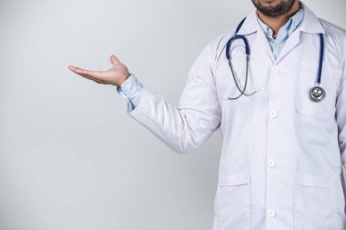 Doktor gri arka planda bir şey tutuyor. Sağlık ve tıbbi konsept.