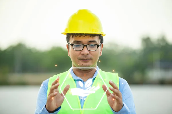 Professional man engineer looking away with pleasure smile while working at ecological green field with solar panels. Photovoltaic power station concept