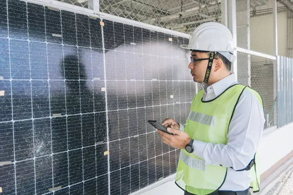 太陽光発電プラントのスマートなエンジニアのメンテナンスは ラップトップとウォルキーのトーキーを使用して太陽光発電モジュールをインストールすることを確認します 持続可能な資源の概念 省エネルギー — ストック写真
