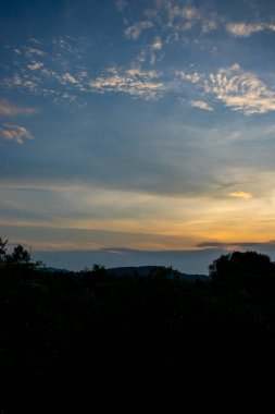 Tranquil sunset landscape with silhouetted tree and vibrant sky.