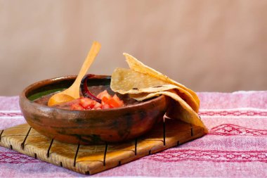 Domates ve tortilla ile kil tabakta pişirilmiş bir fasulye.