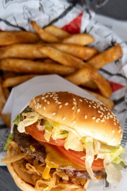 Fast food 'un enfes dünyasında lezzetli bir hamburgerle altın patates kızartmasının yanında mükemmel bir konforlu yemek kombinasyonu sunuluyor..