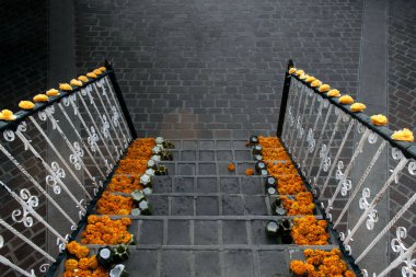 Cempasuchil çiçekleri ve mumlarla süslenmiş bir merdiven.