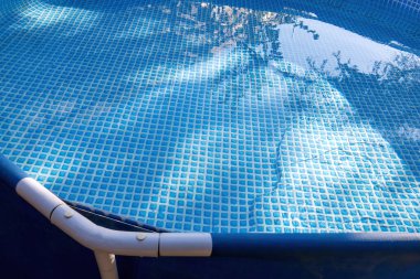 Metal yapısı, mavi tabanı ve metin için alanı olan bir yüzme havuzu.