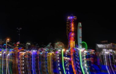 A Mexican fair with rides and lights at night, with space for text clipart