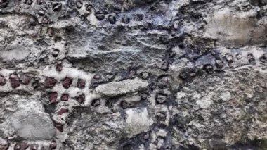 Tarihi bir taş duvarın karmaşık detaylarını keşfedin. Benzersiz dokular ve desenler sergiliyor. Kabataslak yüzey, daha önceki dönemlerin zanaatkarlığına bir göz atmak için malzemelerin bir karışımını içeriyor..