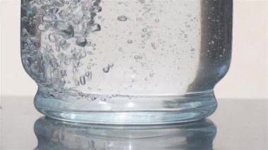 Yavaş çekim, su dolu cam bir kavanozda yükselen büyüleyici kabarcıkları yakalar. Her kabarcık yükseldikçe, hareketin güzelliğini ve suyun dinamik doğasını ortaya çıkaran karmaşık desenler ve yansımalar yaratır..