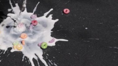 Sütün yavaş çekimde enerjik bir mısır gevreğinin üzerine akışını izleyin. Renkli parçalar dağılıyor ve büyüleyici bir sıçrama yaratıyor. Bu her gün yaşanan güzelliği gözler önüne seriyor..