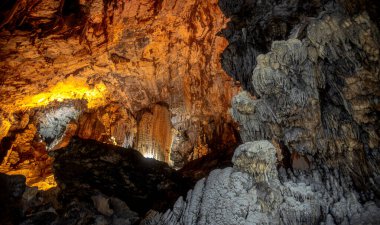 Stunning stalactites and stalagmites decorate the cavernous interiors of Grutas de Cacahuamilpa National Park. Illuminated by warm, ambient lighting, the breathtaking rock formations create a mesmerizing landscape. clipart