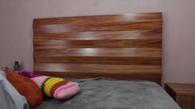 Öğleden sonra yatak odasını toplayan bir adam.