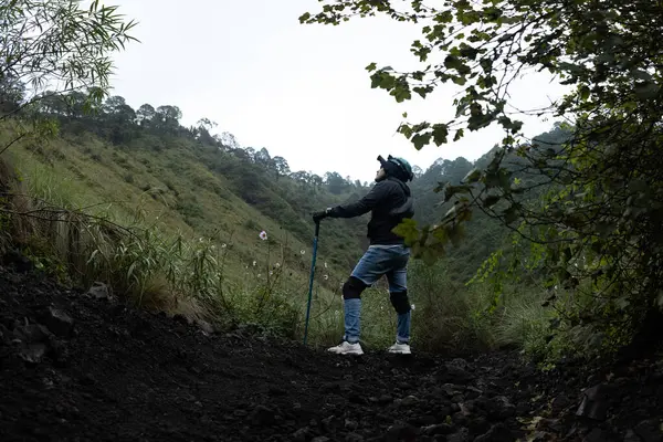 Yürüyüşçüler, yemyeşil yemyeşil ve dramatik kaya oluşumlarıyla çevrili Mexico City 'deki Volkan Ajusco' nun engebeli arazisinde geziniyorlar. Bulutlu gökyüzü maceraya karamsar bir atmosfer ekliyor, grup nefes kesen manzaraları izlemek için duruyor..