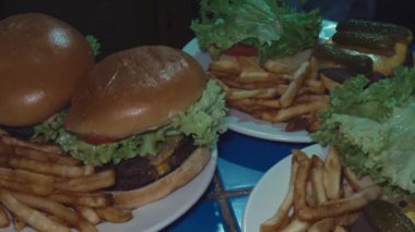Çıtır patatesler ve taze malzemelerle servis edilen çift katlı lezzetli hamburgerler.