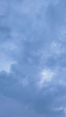 Mavi gökyüzünde toplanan dramatik bulutlar bir yağmur fırtınasından önce atmosferi güçlendirir.
