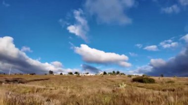 Kuru çayırlarda yuvarlanan bulutlarla geniş bir alan.