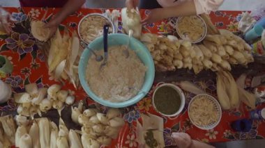 Usta, rengarenk bir mutfak ortamında tavuk ve peynirli tamale yapma sanatı