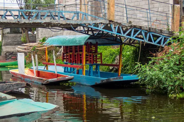Güneşli bir günde Xochimilco 'da bir köprünün altında renkli trajineralar