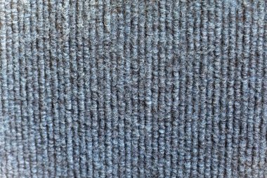 Detaylı bir görüntü, mavi dikey çizgilerle örülmüş kumaşın karmaşık dokusunu yakalar. Kumaş dayanıklı görünüyor ve muhtemelen giysi ya da döşeme için kullanılıyor. İnce renk varyasyonları el yapımı kalitesini vurgular, fashi için uygun hale getirir