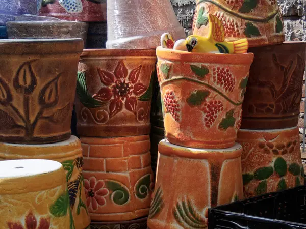 Renkli Talavera çömlekleri Meksika 'da bir pazarda duruyor, karmaşık tasarımlar ve canlı renkler sergiliyor. Sanatçılar bu benzersiz parçaları ustalıkla oluştururlar, genellikle çiçek ve geometrik desenler içerirler..