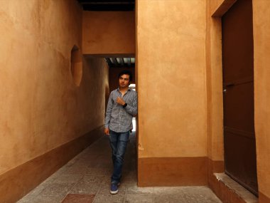 Bir insan Santiago de Queretaro Tarih Merkezi 'nin sıcacık, toprak renkli duvarlarıyla karakterize edilmiş dar bir geçidinde gelişigüzel duruyor. Çevreleyen mimari bölgenin zengin tarihini yansıtıyor..