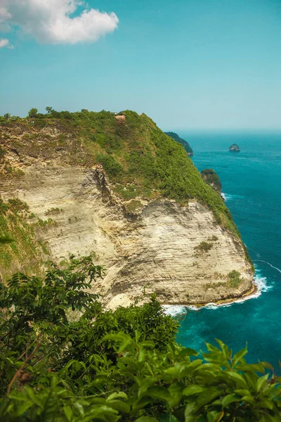 The Atuh beach, Nusa Penida island near Bali, Indonesia. Ocean waves, cliffs with tropical plants. High quality photo