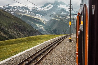 Railway and train in cloudy Gornergrat mountains. Zermatt, Swiss Alps. Adventure in Switzerland. High quality photo