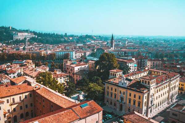 Sunny day in old city Verona, Italy. View from above on red roofs, streets and landmarks. Vacation in Europe. Historical buildings.