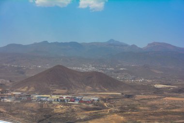 İspanya 'daki Tenerife Güney Havaalanı' na yaklaşan bulanık bir uçak penceresinden görüntü. Adanın kırsalına bakan.
