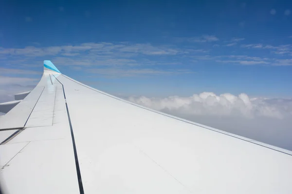 Bir Uçak Penceresinden Mavi Gökyüzü Beyaz Bulutlu Bir Uçak Kanadı — Stok fotoğraf