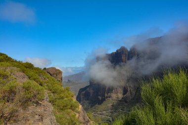 Low hanging clouds in the green Teno Mountains near Masca with serpentine roads on the Canary Island of Tenerife, Spain