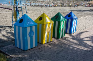 Waste bins for separating waste into 4 different containers, of different colors, on a beach on the island of Tenerife, Costa Adeje, Spain