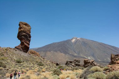 İspanya 'nın Tenerife Kanarya Adası' ndaki Teide Ulusal Parkı 'nda volkanik kayadan oluşan tuhaf şekilli Roque Cinchado kayası. Teide Dağı ve mavi gökyüzü manzaralı.