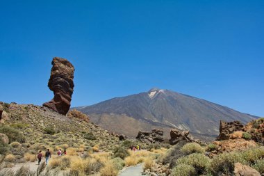 İspanya 'nın Tenerife Kanarya Adası' ndaki Teide Ulusal Parkı 'nda volkanik kayadan oluşan tuhaf şekilli Roque Cinchado kayası. Teide Dağı ve mavi gökyüzü manzaralı.