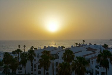 Gün batımında yelkenli teknesiyle denize açılan bungalov kompleksini görün, Costa Adeje, İspanya, Tenerife