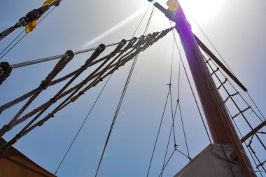 Mavi gökyüzüne yelken açmamış bir yelkenli gemisinin direği