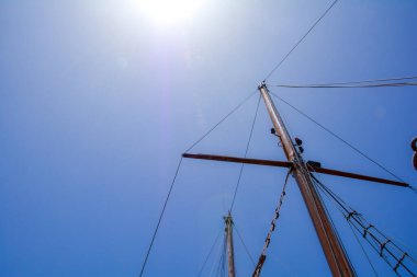 Mavi gökyüzüne yelken açmamış bir yelkenli gemisinin direği
