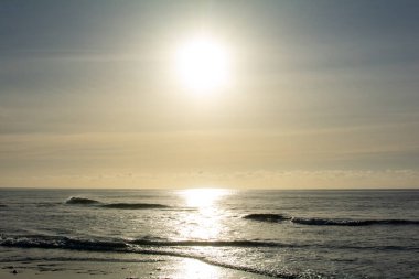 Kumlu bir kumsalın etrafında gün doğumu
