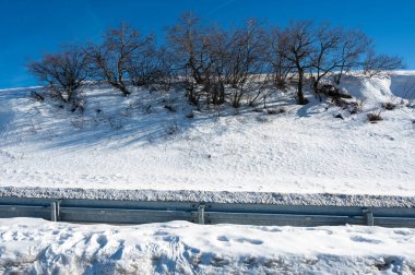 Ağaçlar, yollar, yüksek Rhoen, Hesse, Almanya 'da bol kar ve mavi gökyüzü.