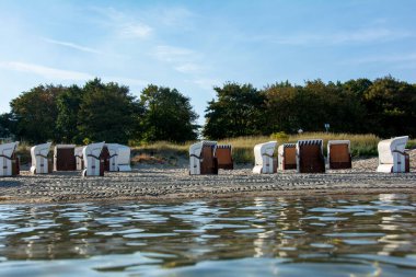 Baltık Denizi 'nin suyundan, Poel, Almanya' daki kumlu sahildeki plaj sandalyelerinin görüntüsü