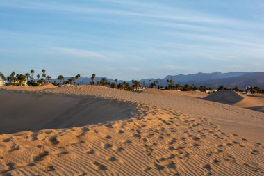 Maspaloma 'nın kum tepecikleri, İspanya' nın Gran Kanarya Adası 'ndaki Playa del Ingls kasabasına bakıyor. Dev kum tepeleri küçük bir çöle benzer ve doğa koruma alanıdır.