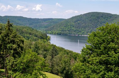 Edersee Gölü manzarası, yelkenli tekneler, bir ağaç, mavi gökyüzü ve bulutlar, Hesse, Almanya 'da