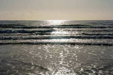 Gün doğumunda gökyüzü ile denizde dalgalar