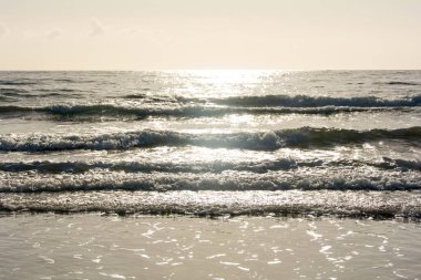 Gün doğumunda gökyüzü ile denizde dalgalar