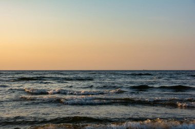 Denizde dalgalar, akşam ışığında gökyüzü...