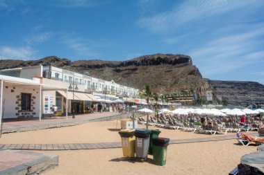 Puerto de Mogn, Gran Canaria, İspanya, 1 Eylül 2023 - Şehirde bir sürü insan ve mavi gökyüzü olan kumsal