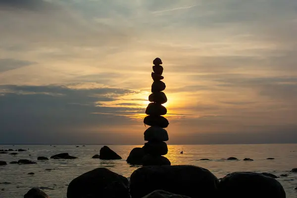 Stock image Stacked stones on a beach on the Baltic Sea coast at orange sunset