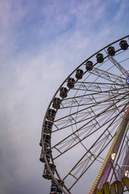 Alacakaranlıkta ışık saçan dönme dolabın parçası.